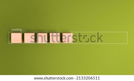 Wooden block in progress bar for loading on green background. Royalty-Free Stock Photo #2133206511