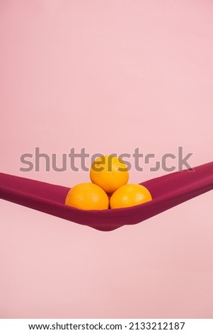four oranges cut in half on a red cloth in front of a peach background as a symbol of the pelvic floor, no people Royalty-Free Stock Photo #2133212187
