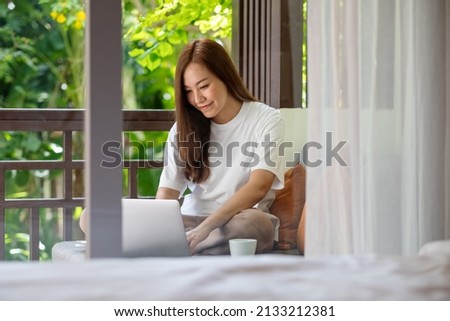 Portrait image of a young woman using laptop computer for working or studying online at home