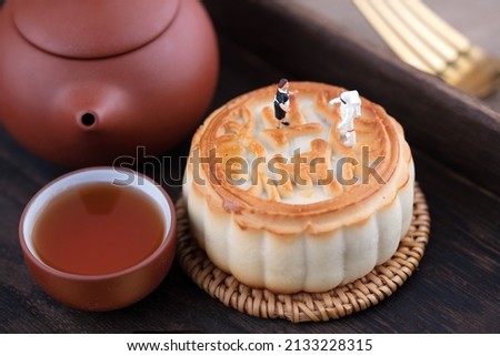 The astronaut and the chef are talking above the mooncake.The Chinese character in the picture means "five kinds of nuts"