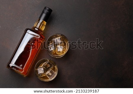 Scotch whiskey bottle and glasses on stone table. With copy space. Top view flat lay Royalty-Free Stock Photo #2133239187
