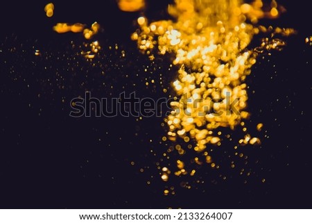 Gold bokeh from water of lights on black background