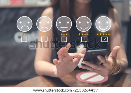 Customer review good rating concept hand pressing five star and smile face icon on visual screen for positive customer feedback testimonial.