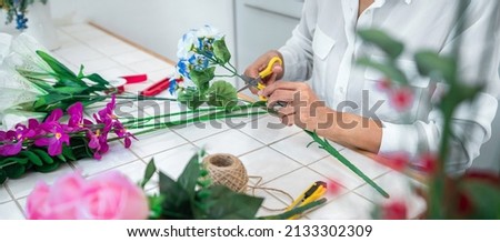 Arranging artificial flowers decoration at home, Young woman florist work making organizing diy artificial flower, craft and hand made concept.