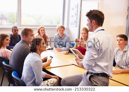 Teacher With College Students Giving Lesson In Classroom Royalty-Free Stock Photo #213330322