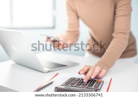 financial adviser working with calculator at office. accountant doing accounting and calculating revenue and budget. bookkeeper making calculation. finance and economy concept. online shopping. Royalty-Free Stock Photo #2133306741