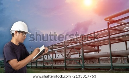 Industrial technician inspecting pipeline at petrochemical industrial zone. Royalty-Free Stock Photo #2133317763