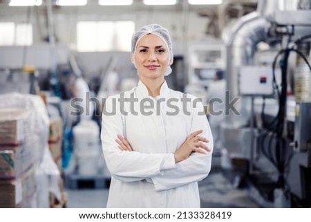 Portrait of a proud female food plant worker smiling at the camera.