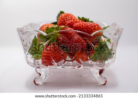 Pile of delicious organic red strawberries in a bowl and with white background, this fruit provides many vitamins if taken fresh and with the white background is ideal for cutting.