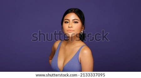 Asian 20s Woman chubby wear sport bra in purple color or Very Peri world trend over purple background. Half body Female black hair express feeling strong smile on face eyes in studio lighting