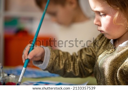 Little kid drawing and painting a picture. Children's art and creativity.