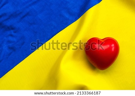 National flag of Ukraine background with a red heart and copy space. Donation concept