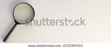 Photo of magnifying glass on left side over white background with copyspace for put your text or logo.,Flat lay top view mock-up item concept.