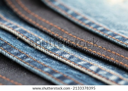 Detail of denim fabric and seams.. weathered denim fabric.. the selected focus point. Jean fabric detail. Royalty-Free Stock Photo #2133378395