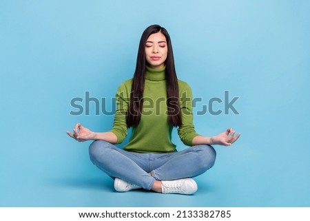 Full size photo of sweet young brunette lady sit wear jumper jeans sneakers isolated on blue color background.