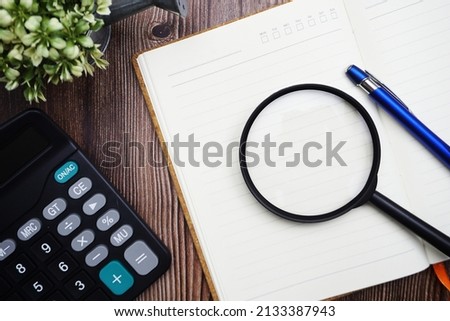 Planning schedule with magnifying glass and calculator on wooden background