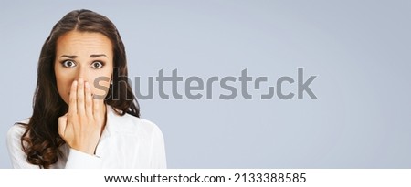 Unbelievable news! Excited surprised, shocked businesswoman. Young business woman covering mouth by her hand. Isolated on gray background. Wide banner composition. wow awe