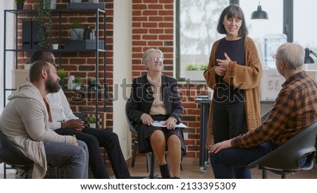 Woman sharing therapy progress with group at aa meeting and receiving applause. People clapping hands and celebrating addiction success and achievement at rehabilitation program session. Royalty-Free Stock Photo #2133395309