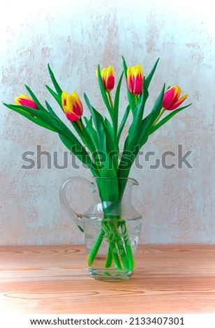 Bouquet of fresh pink tulips on a shelf in front of a stone wall. Beautiful tulip flower bouquet on wooden table in vase. Valentine's day or mother's day concept