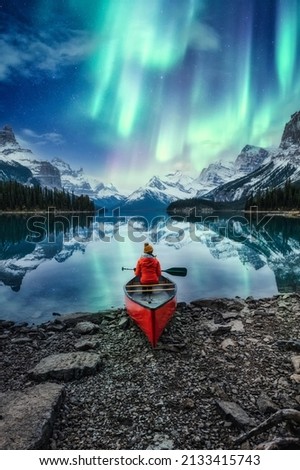 Beautiful aurora borealis over spirit island with female traveler on canoe at Jasper national park, AB, Canada Royalty-Free Stock Photo #2133415743