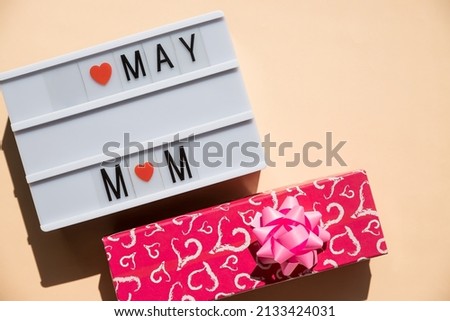 Happy Mother's Day card concept. I love mom, red hearts, text in a light box. Copy space, top view, flat lay.White lightbox with words ans symbols.