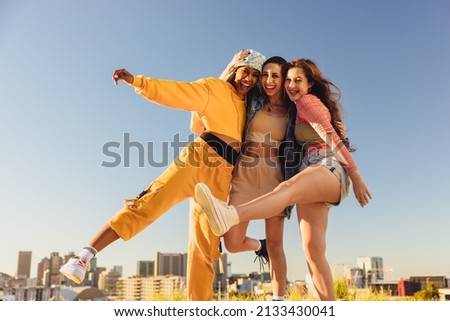 Living life to the fullest. Cheerful female youngsters smiling and having fun while standing together outdoors. Group of generation z friends making happy memories together. Royalty-Free Stock Photo #2133430041