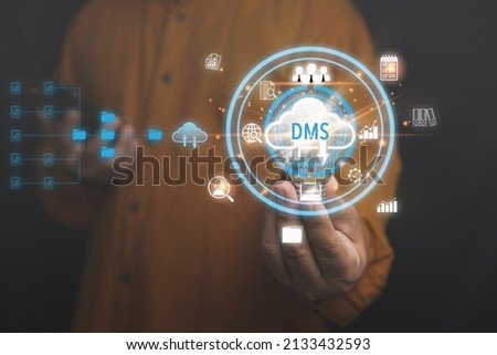 A Businessman holding a light bulb DMS with business icons. Database and process automation to manage files, knowledge, and Document of corporate. Document Management System.