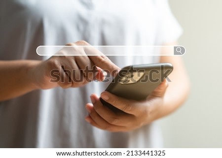 Close up of woman hand touching mobile phone as background of search engine browser