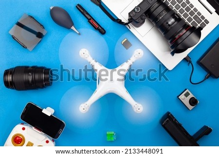 Digital camera with lenses and equipment of the professional photographer on blue paper background