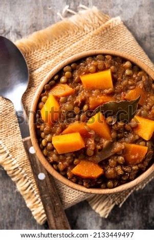 Lentil stew ragout with pumpkin and carrot in bowl on wooden table