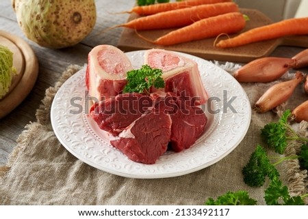 Beef meat, marrow bones and fresh vegetables - ingredients for homemade broth or soup