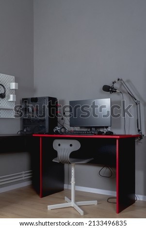 Workplace of a teenage boy with a black and red desk, computer and chair.
