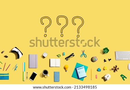 Question marks with collection of electronic gadgets and office supplies