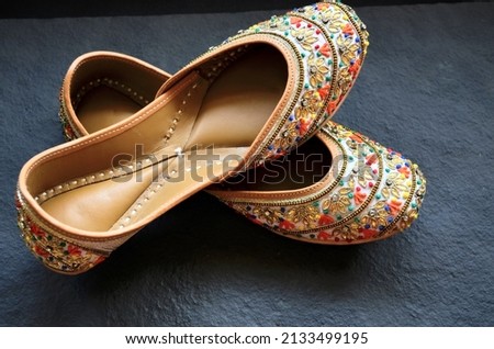 Punjabi jutti. The jutti is the traditional footwear of North India. Originally made completely of local leather. Beautiful metallic thread work. Embroidered. One of the jutti from my collection.flat. Royalty-Free Stock Photo #2133499195