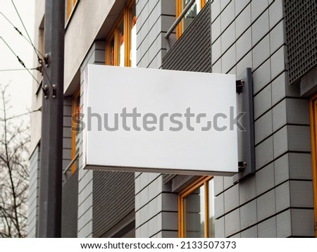 Empty display on a facade of a business inside the building. Template for testing a logo or a sign next to a wall. Blank mockup to advertise a brand. Signboard of a cafe a restaurant or an office.