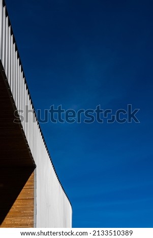 Facade of a modern public building against a blue sky background. Photo taken at noon on a sunny day.