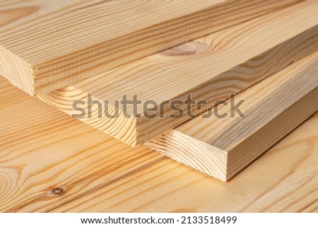 Stacks of pine wood planks. Natural rough wooden boards boards, lumber, industrial wood, timber. Royalty-Free Stock Photo #2133518499
