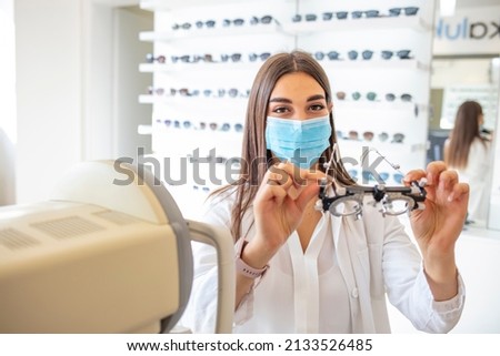 A beautiful young optometrist is holding optical lenses for examining eyesight. Medical concept. An ophthalmologist keeps a test tool for choosing a lens in the office.