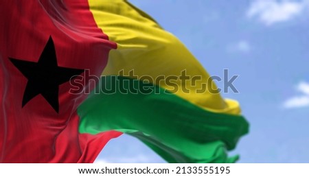 Detail of the national flag of Guinea-Bissau waving in the wind on a clear day. Guinea-Bissau is a country in West Africa. Selective focus.