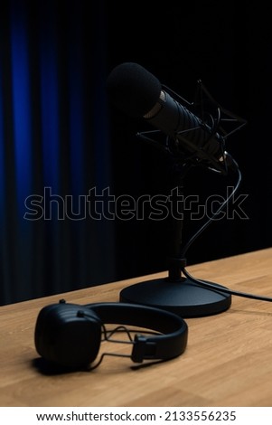 Podcasts and Stream. Flat lay. Studio condenser microphone black with professional headphones. Radio, working with sound, podcasts, blogging.