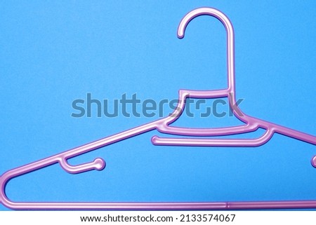Blue background and pink hangers.