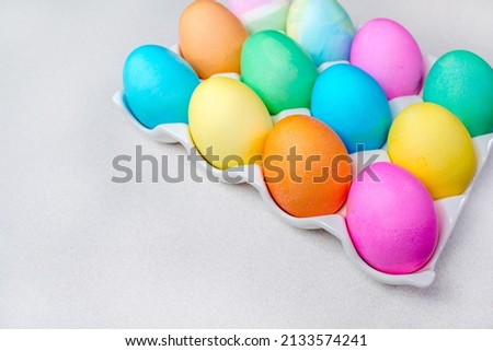Bright colorful painted Easter eggs lying on white table. Traditional decoration