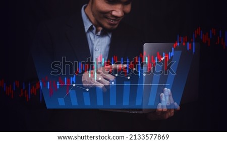 Businessman holding computer trading online or investment stock market with digital chart visual screen technology