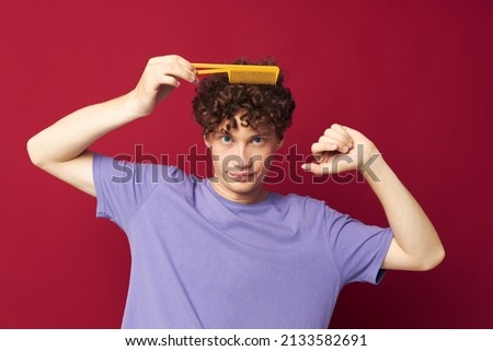 cute red-haired guy in purple t-shirts with a comb isolated background
