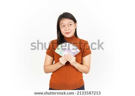 Holding Ten Thousand and Twenty Thousand Indonesian Rupiah Banknote Of Beautiful Asian Woman Isolated On White Background Royalty-Free Stock Photo #2133587213
