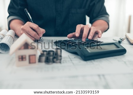 Architect engineer use calculator check cost house design on blueprint. Cost House planning design and construction concept.