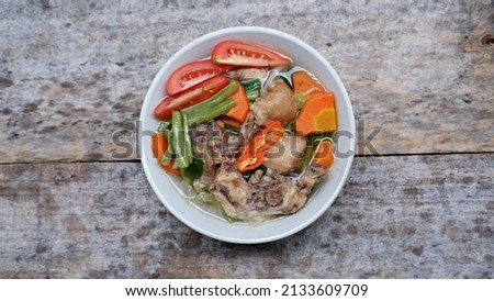 Chicken soup with vegetables on a wooden background 