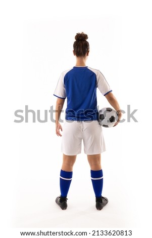 Full length rear view of biracial young female soccer player holding ball against white background. unaltered, sport, sports uniform, copy space, athlete and women's soccer. Royalty-Free Stock Photo #2133620813