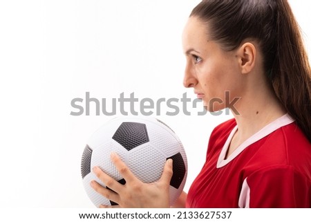 Caucasian young female player holding soccer ball against white background with copy space. unaltered, sport, sports uniform, athlete and women's soccer.