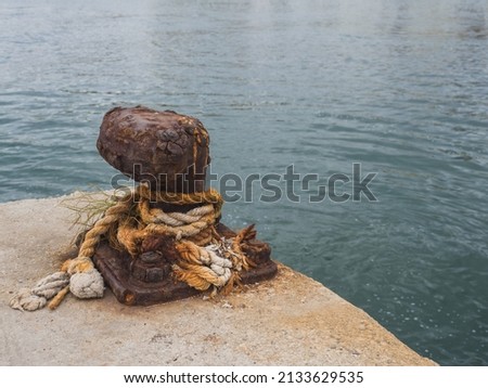 Rusty mooring post next to port